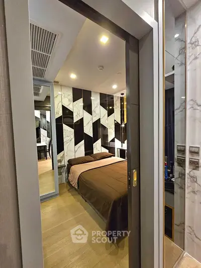 Modern bedroom with stylish marble accent wall and cozy brown bedding