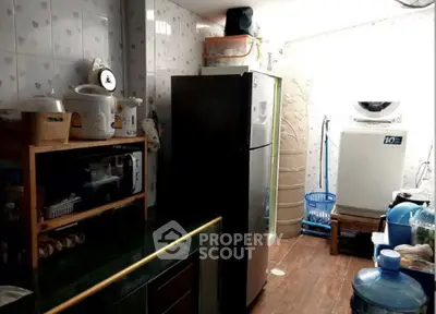 Compact kitchen with fridge, washing machine, and microwave in cozy layout
