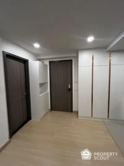 Modern apartment entrance with sleek wooden doors and built-in storage