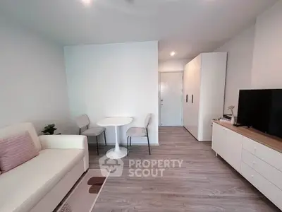 Modern living room with minimalist decor, featuring a cozy sofa, dining set, and sleek TV stand.