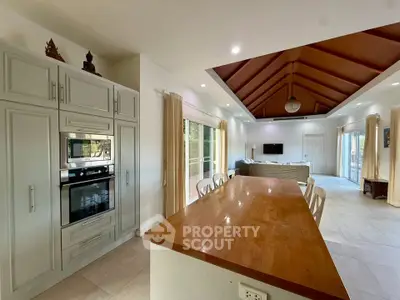 Spacious open-plan kitchen and living room with high ceilings and modern appliances.
