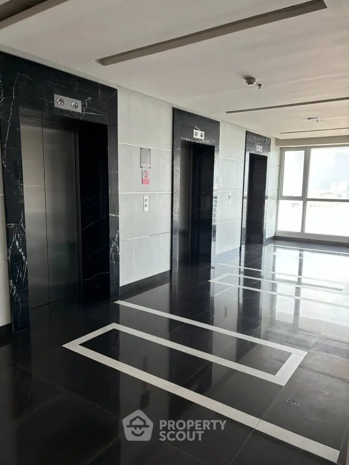 Modern building corridor with sleek elevators and polished flooring