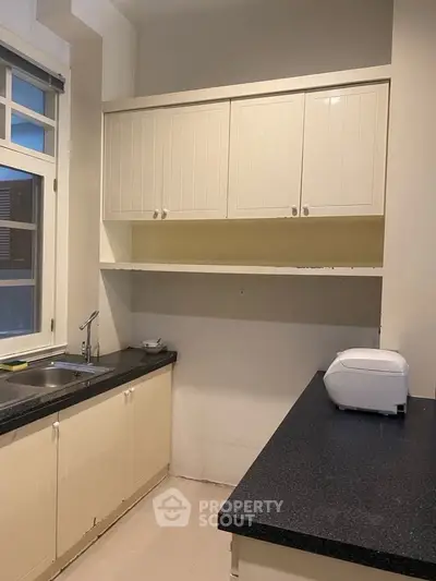 Charming kitchen with ample cabinetry and sleek countertops, perfect for culinary enthusiasts.