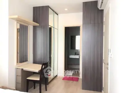 Modern bedroom with built-in wardrobe and vanity, featuring sleek design and ample storage space.