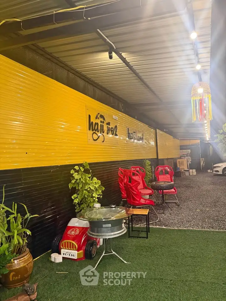 Stylish outdoor seating area with vibrant decor and unique lighting, perfect for relaxation and social gatherings.