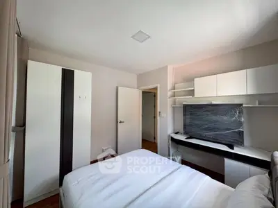Modern bedroom with sleek furniture and large TV, perfect for comfortable living.