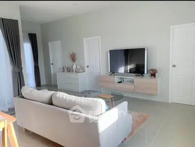 Modern living room with sleek furniture and wall-mounted TV