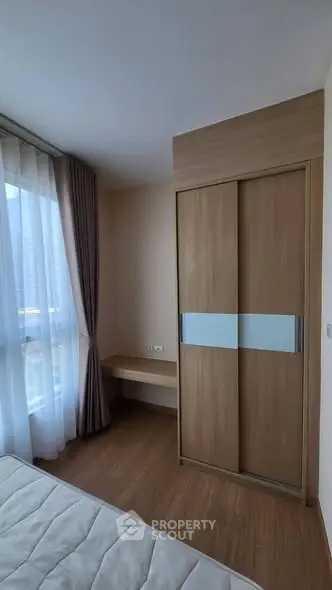 Modern bedroom with wooden wardrobe and large window with curtains