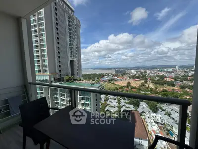 Stunning high-rise balcony view overlooking cityscape and ocean, perfect for urban living.