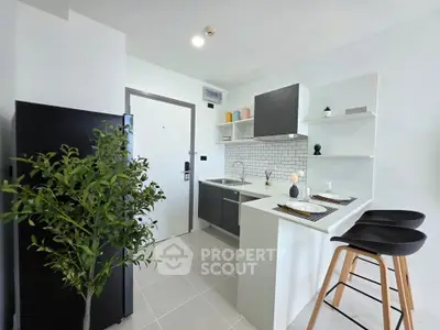 Modern kitchen with sleek design, featuring a breakfast bar and stylish black appliances.