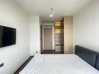 Modern bedroom with sleek design, featuring a wall-mounted TV and built-in wardrobe.