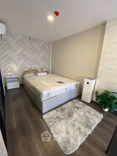 Modern bedroom with stylish decor and cozy ambiance, featuring a plush rug and elegant furnishings.