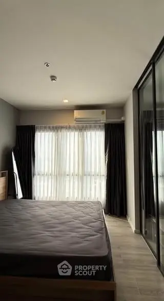 Modern bedroom with large windows and mirrored closet doors