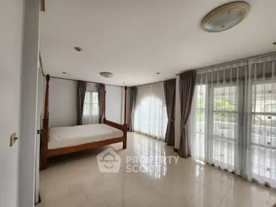 Spacious bedroom with large windows and elegant curtains