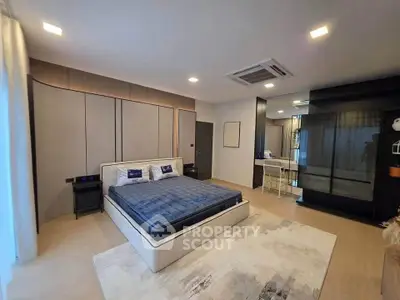 Spacious modern bedroom with stylish decor and ample natural light.