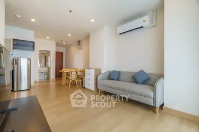 Modern living room with wooden flooring and minimalist furniture in a bright apartment.