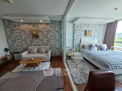 Modern open-plan living room and bedroom with stylish decor and natural light.