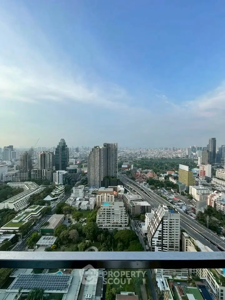 Stunning cityscape view from high-rise balcony showcasing urban skyline and lush greenery.