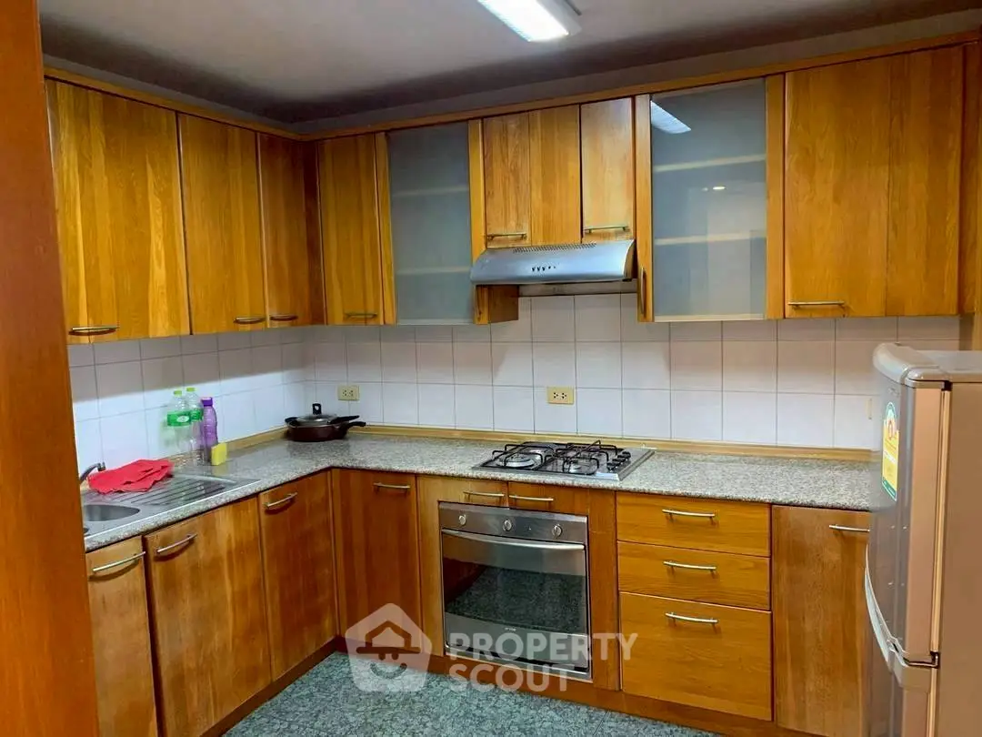 Spacious kitchen with wooden cabinets and modern appliances in a cozy home.
