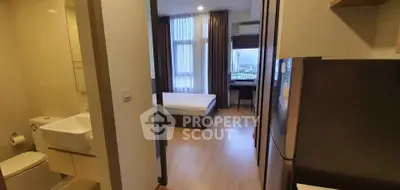 Modern apartment interior with bedroom and bathroom, featuring sleek design and city view.