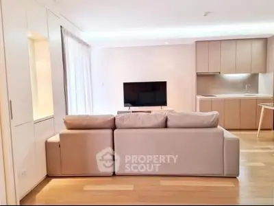 Modern living room with sleek kitchen and cozy sofa, perfect for urban living.