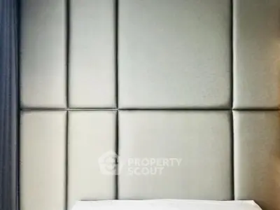 Luxurious bedroom with elegant padded wall design and crisp white bedding