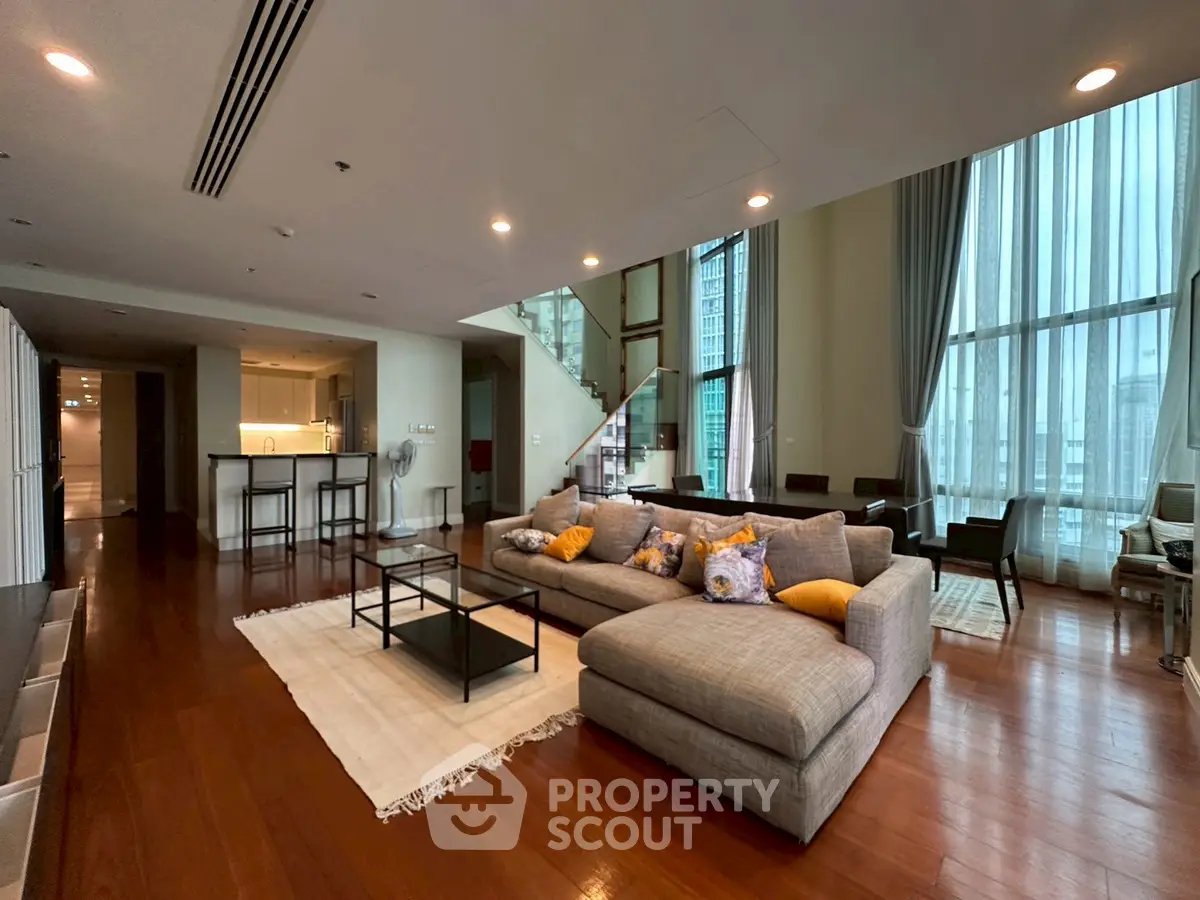 Luxurious open-plan living room with modern furniture and high ceilings in a stylish apartment.