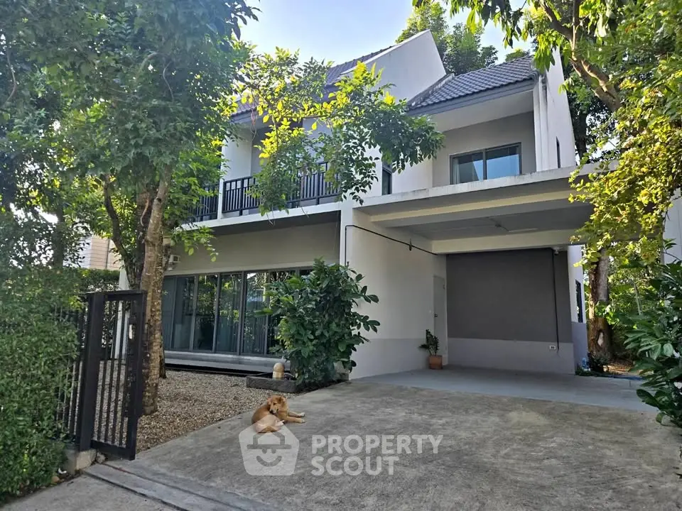 Charming two-story house with lush greenery and spacious driveway
