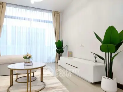 Modern living room with elegant decor and large windows for natural light.