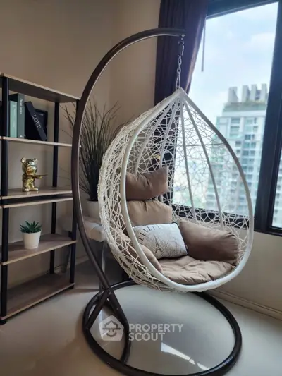 Stylish modern living room with hanging chair and city view, perfect for relaxation.