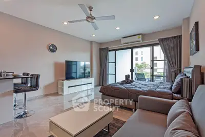 Modern studio apartment with open layout, featuring a cozy living area, sleek kitchen, and balcony access.