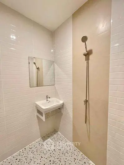 Modern minimalist bathroom with sleek shower and wall-mounted sink.