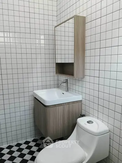 Modern bathroom with sleek fixtures and checkered floor tiles.