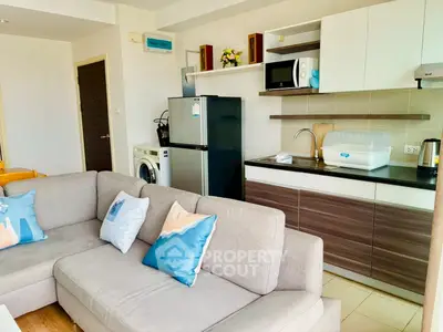 Modern open-layout kitchen with cozy living room and appliances in a stylish apartment.