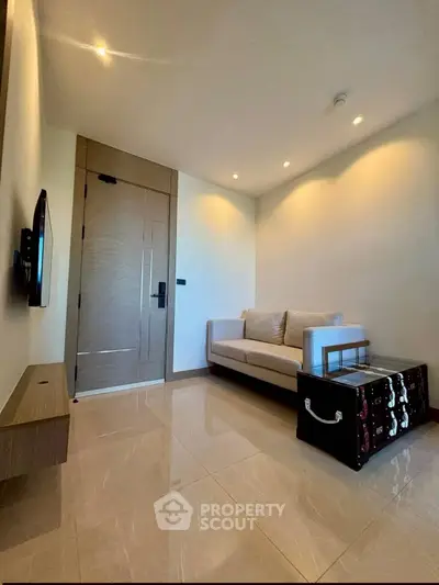 Modern living room with sleek sofa and wall-mounted TV in a stylish apartment.