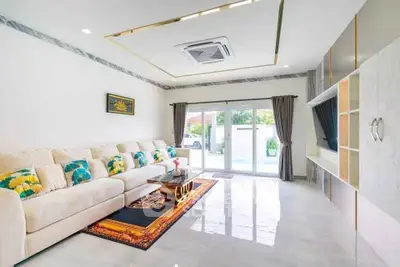Spacious modern living room with elegant decor and pool view, perfect for luxury living.