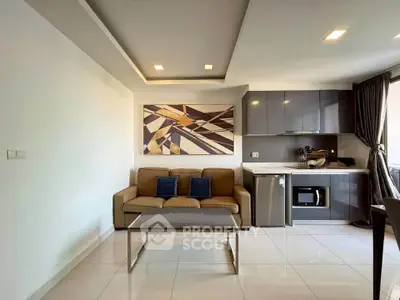 Modern living room with sleek kitchen, stylish decor, and natural light.
