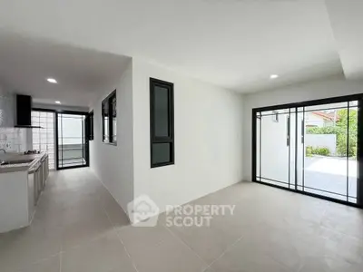 Spacious open-plan living area with modern kitchen and large sliding doors to patio.