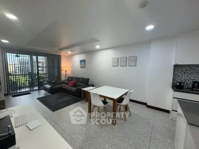 Spacious modern living room with open kitchen and balcony view, perfect for urban living.