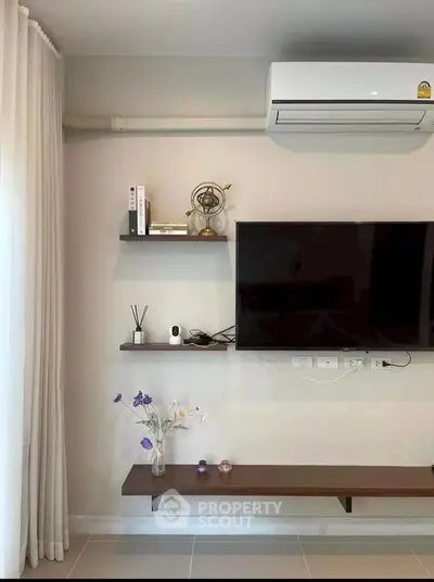 Modern living room with wall-mounted TV and air conditioning, featuring minimalist shelves and decor.