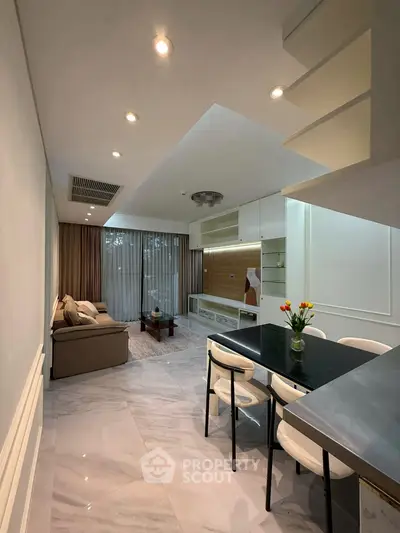 Modern living room with elegant decor and open layout, featuring a cozy sofa and stylish dining area.