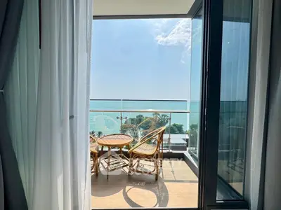 Stunning ocean view from a modern balcony with elegant seating, perfect for relaxation.