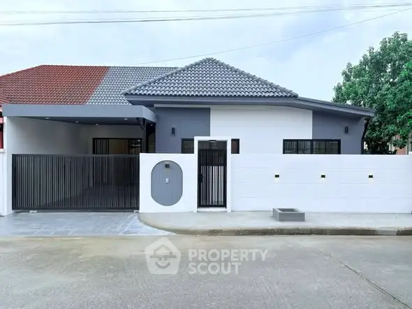 Modern single-story house with stylish facade and gated entrance.