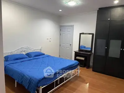 Spacious bedroom with modern furnishings and wooden flooring