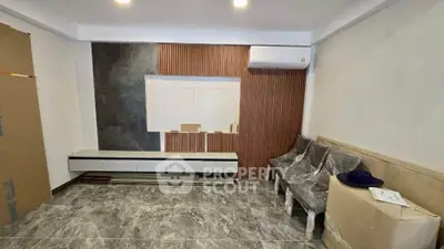 Modern living room with sleek design and air conditioning, featuring stylish wall paneling and marble flooring.