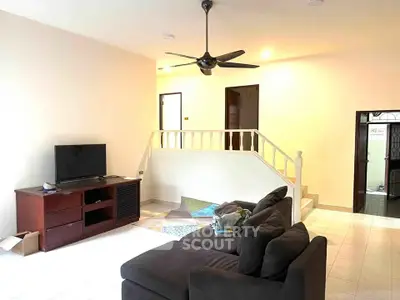 Spacious living room with modern furniture and ceiling fan in a cozy home setting.
