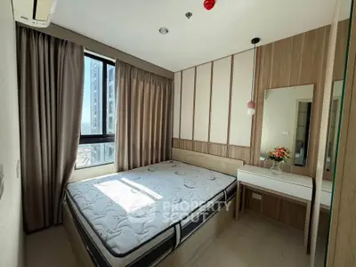 Cozy bedroom with modern decor and large window offering natural light