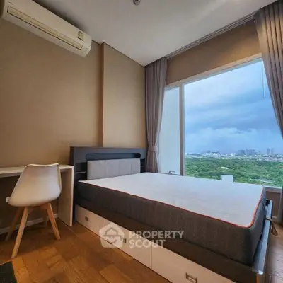 Modern bedroom with large window offering stunning city view and stylish furniture.