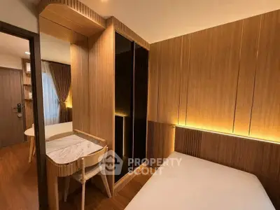 Modern bedroom with wooden paneling and ambient lighting, featuring a cozy bed and a stylish desk.