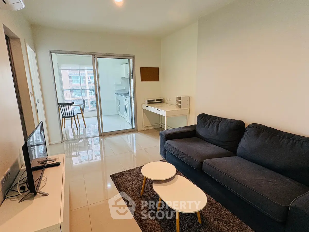 Modern living room with cozy sofa and sleek furniture, featuring a bright open layout and stylish decor.